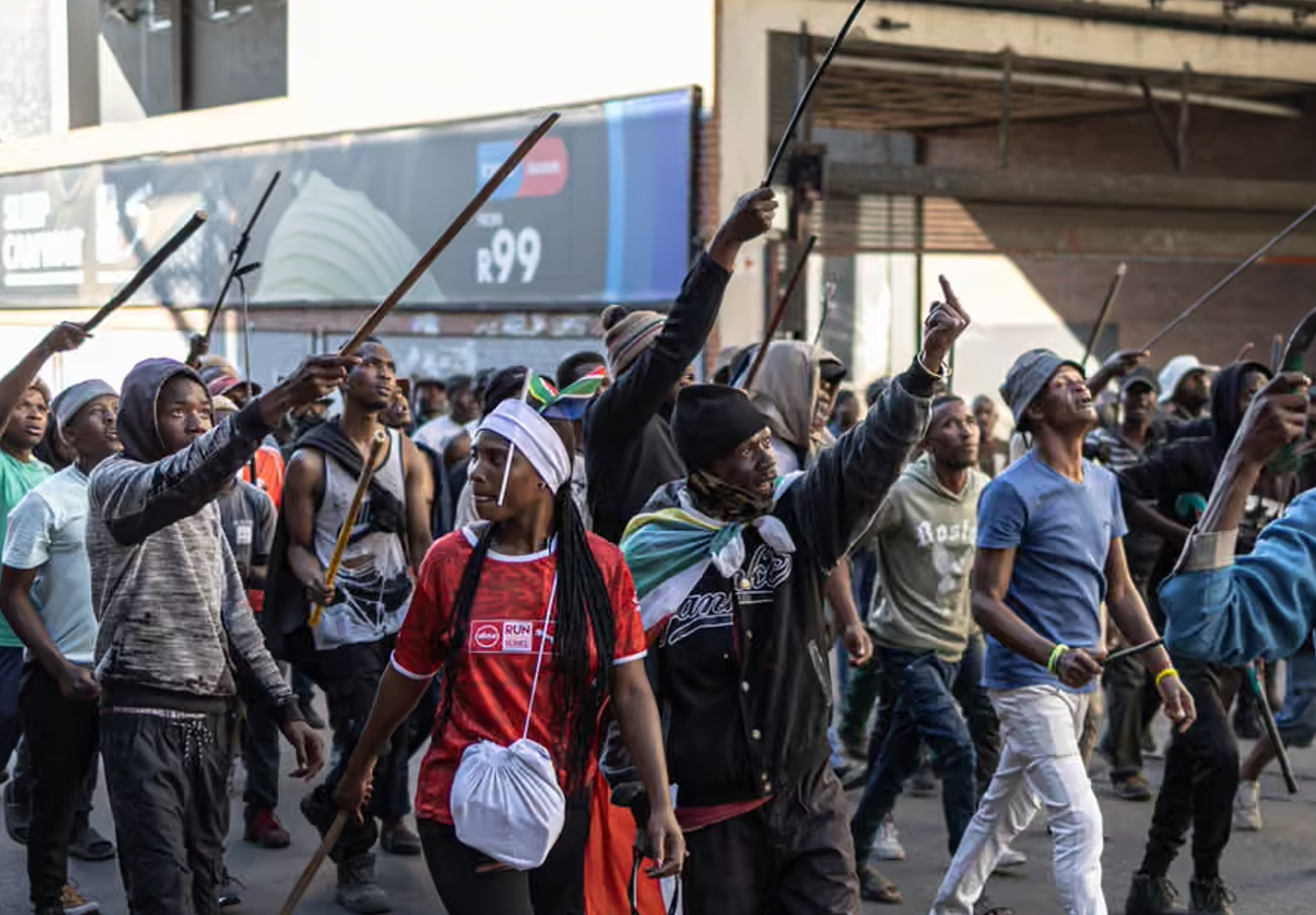 Armed protesters march in Alexandra, near Johannesburg, on 16 July. Photograph: Emmanuel Croset/AFP/Getty Images
